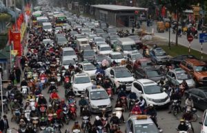 Мотоциклы пытаются протиснуться между машинами в Ханое