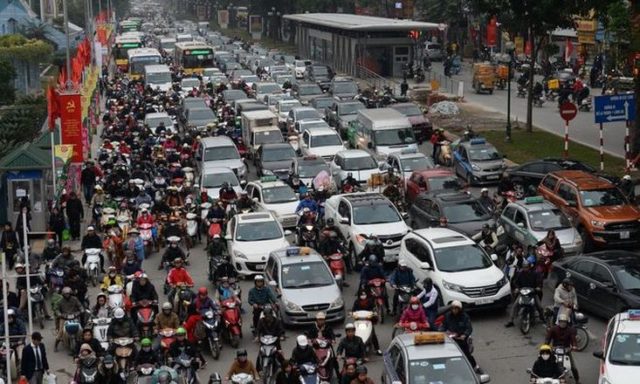 Мотоциклы пытаются протиснуться между машинами в Ханое