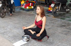 Иностранка медитирует и просит деньги на улице острова Фукуок