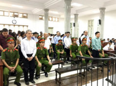 Обвиняемые в зале суда в Ханое в понедельник, среди них Ha Van Tham - бывший глава Ocean Bank (cправа)