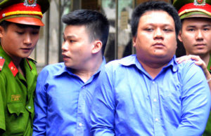 Полиция сопровождает в суд двух мужчин за кражу сотового телефона у иностранца в Сайгоне.